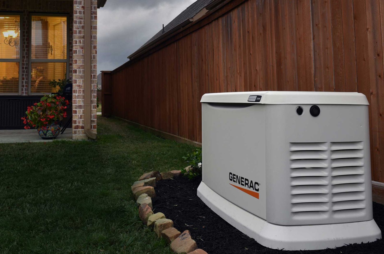 Generac standby generator installed beside a brick home