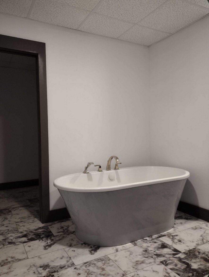 Stone freestanding soaking tub on marble tile